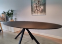 Deze ovale eettafel is gemaakt van massief eiken met een afwerking in de kleur VantaBlack en biedt plaats aan zes tot acht personen.