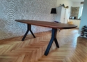 De ovale notenhouten eettafel is 220x100cm, heeft afgeronde hoeken en stalen poten voorzien van een houten accent. De eettafel biedt plaats aan zes tot acht personen.