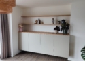 Dit dressoir is gemaakt van HPL met een eiken bovenpaneel met zwevende planken en kastdeuren in de kleur Dakar Grijs U717.