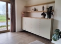 Dit dressoir is gemaakt van HPL met een eiken bovenpaneel met zwevende planken en kastdeuren in de kleur Dakar Grijs U717.